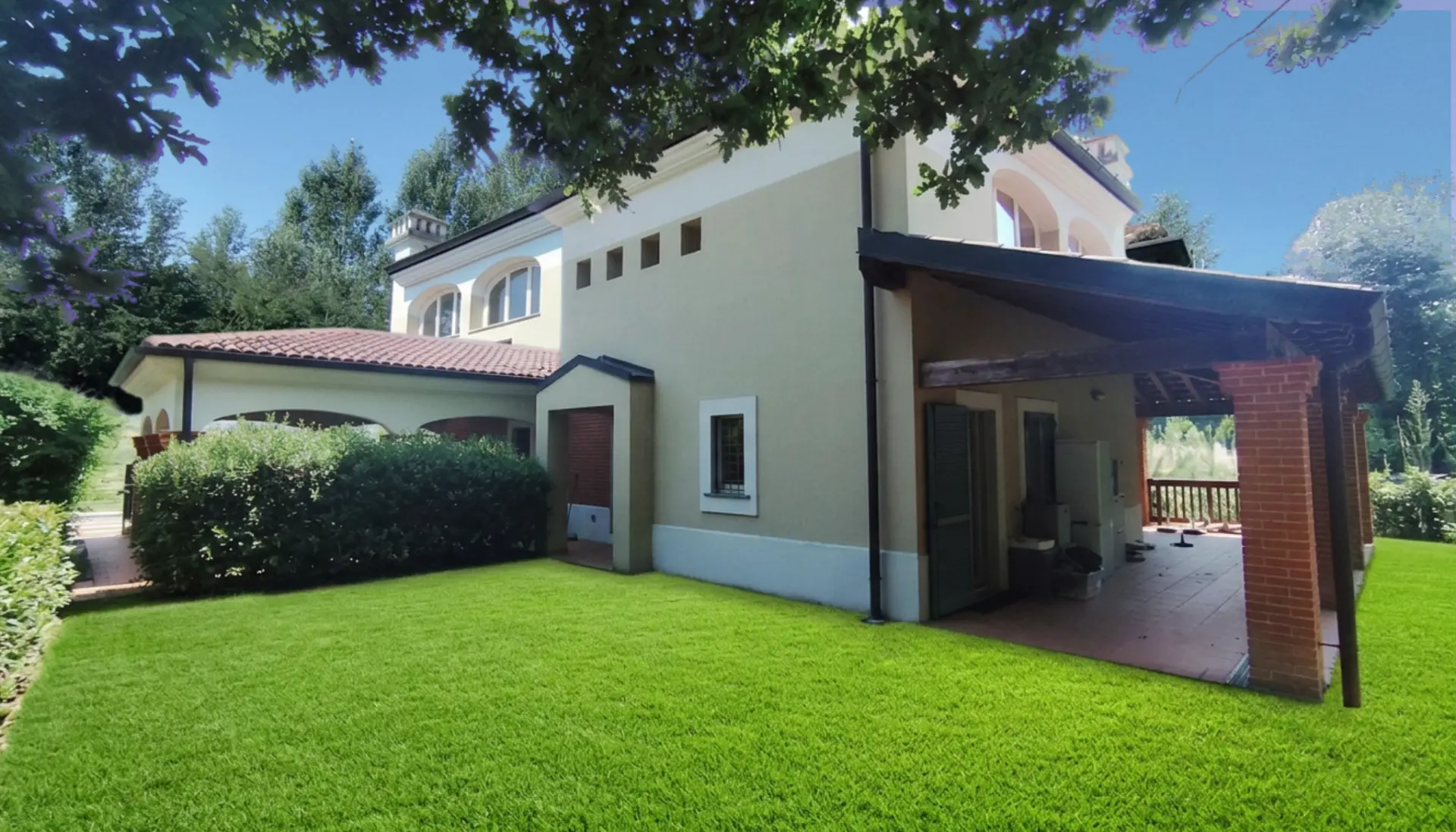 Vista posteriore della villa con prato e portico