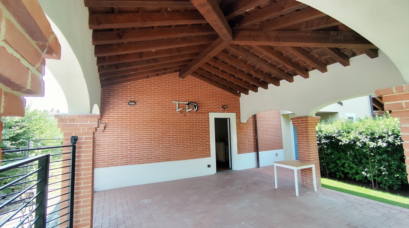 Terrazza coperta con travi in legno e archi in mattoni