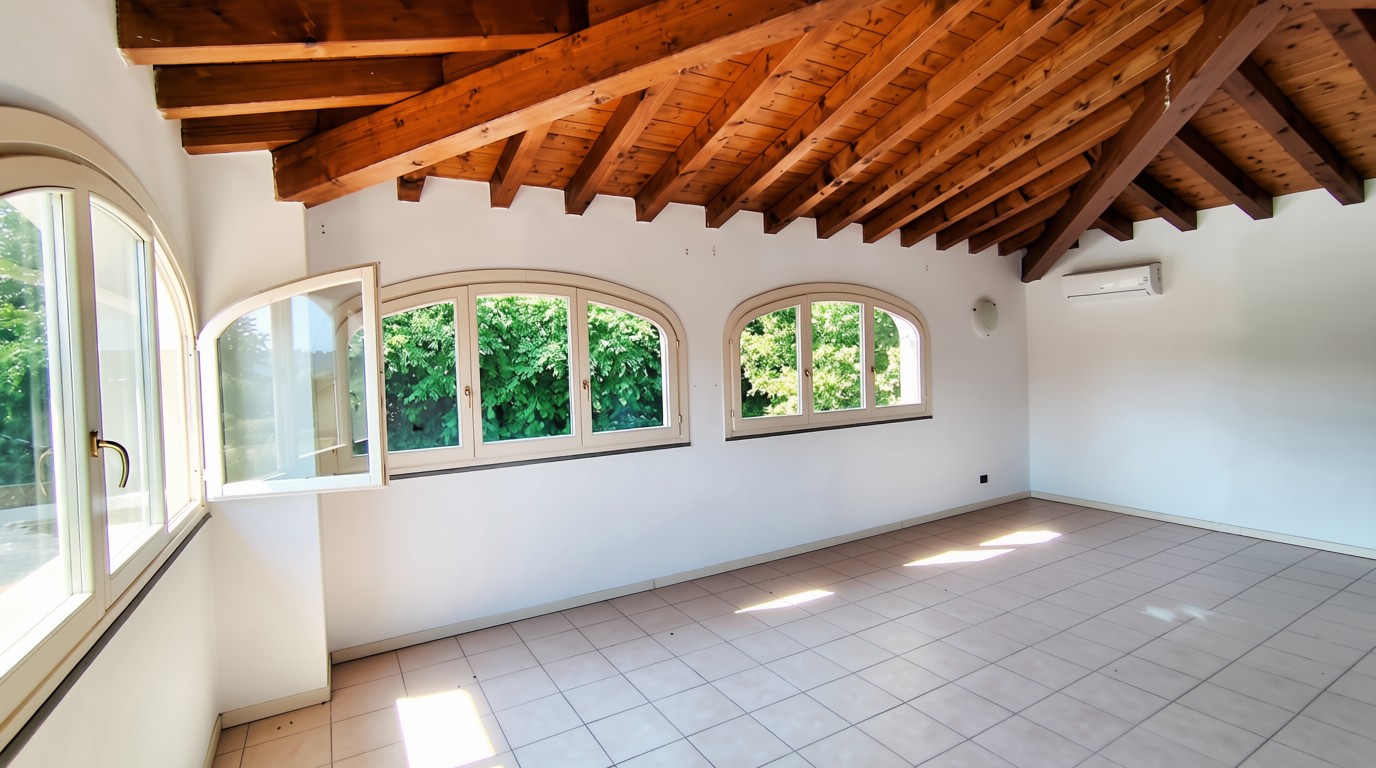 Mansarda luminosa con travi in legno e affaccio sul verde